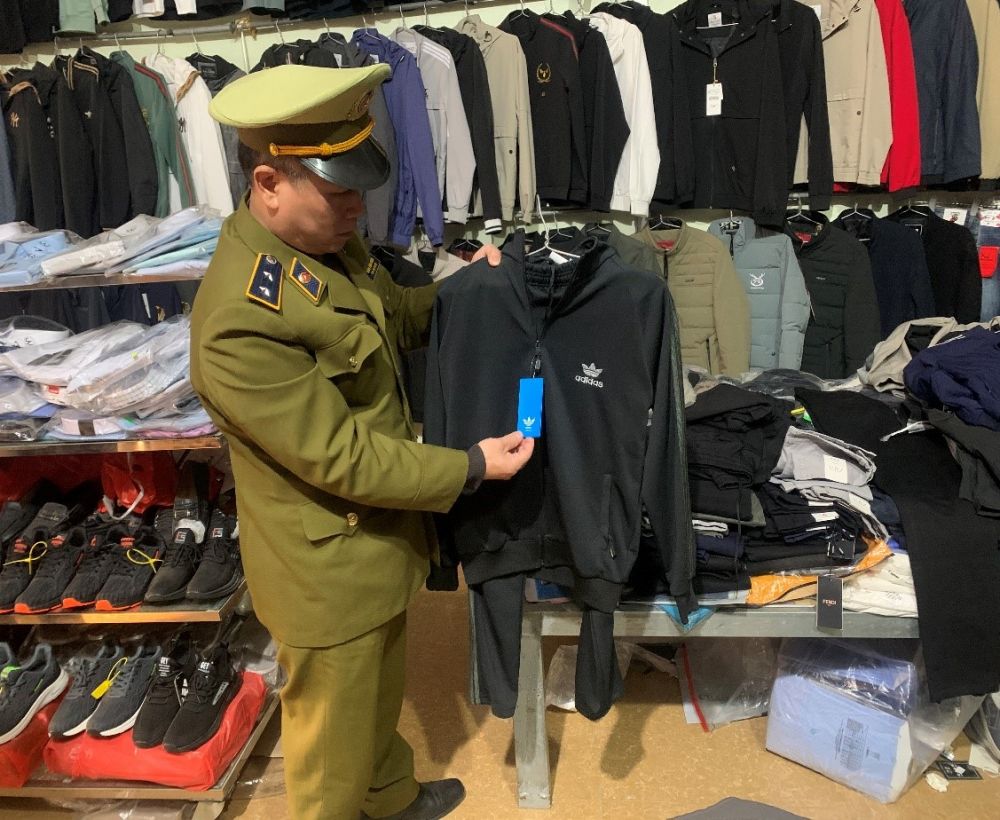 C&ocirc;ng chức Tổ QLĐB Tr&agrave;ng Định đang kiểm tra h&agrave;ng h&oacute;a tại cửa h&agrave;ng.