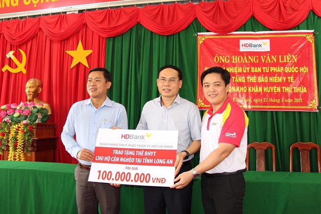 Ông Hoàng Văn Liên – Phó Chủ nhiệm Ủy ban Tư pháp của Quốc hội  (đứng giữa) và đại diện HDBank trao tặng thẻ bảo hiểm cho các hộ cận nghèo.