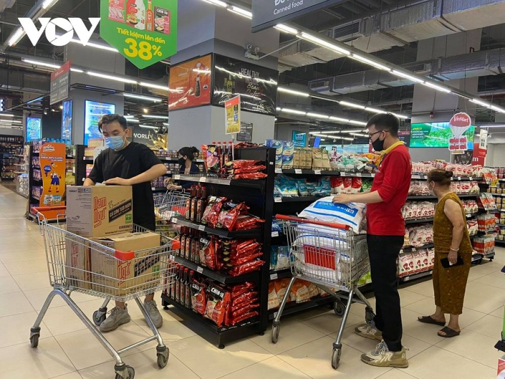 Nhân viên siêu thị bổ sung hàng hóa, bảo đảm cung cấp đủ hàng hóa thiết yếu cho người dân