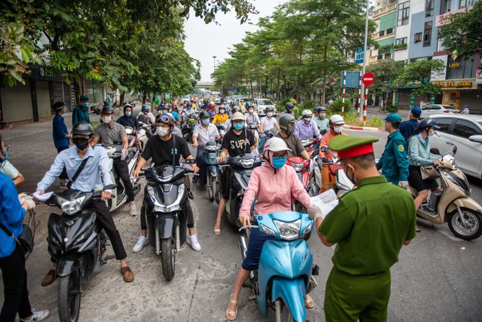 Việc yêu cầu người dân xuất trình nhiều loại giấy tờ để kiểm tra đã khiến xảy ra tình trạng ùn ứ tại các chốt kiểm soát dịch trên địa bàn TP Hà Nội. Ảnh: Hải Nam.