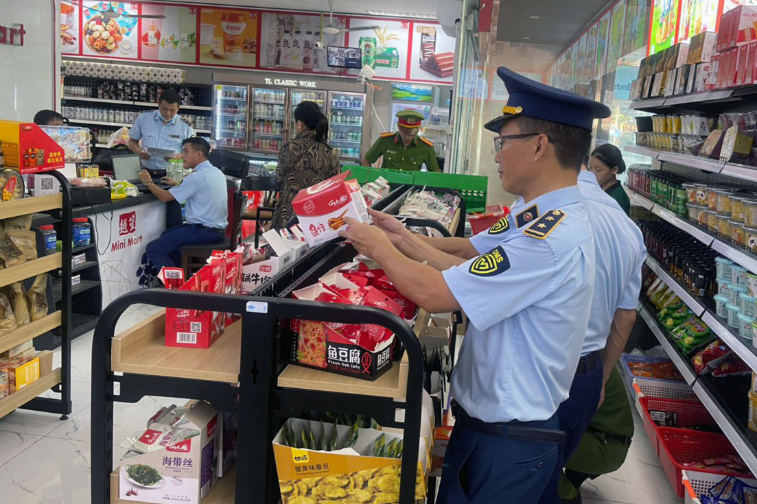 Cán bộ Quản lý thị trường tỉnh Bắc Giang phối hợp với lực lượng công an kiểm tra cửa hàng kinh doanh.