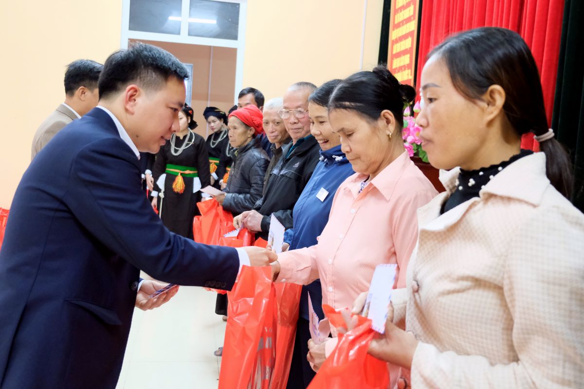 Bí thư Đảng ủy xã Mường Lai Triệu Văn Huấn trao quà của các nhà hảo tâm đến các hộ nghèo.