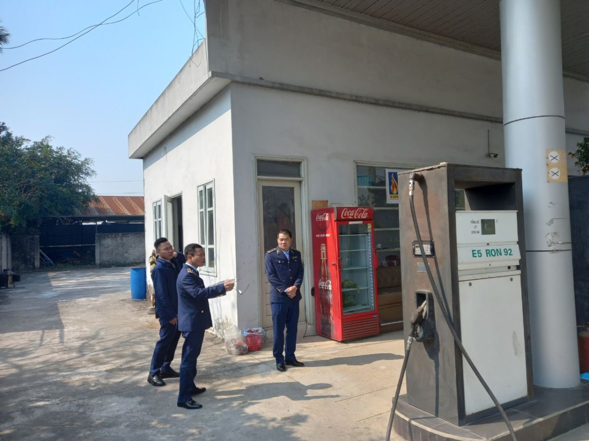 Lực lượng chức năng kiểm tra cửa hàng xăng dầu.
