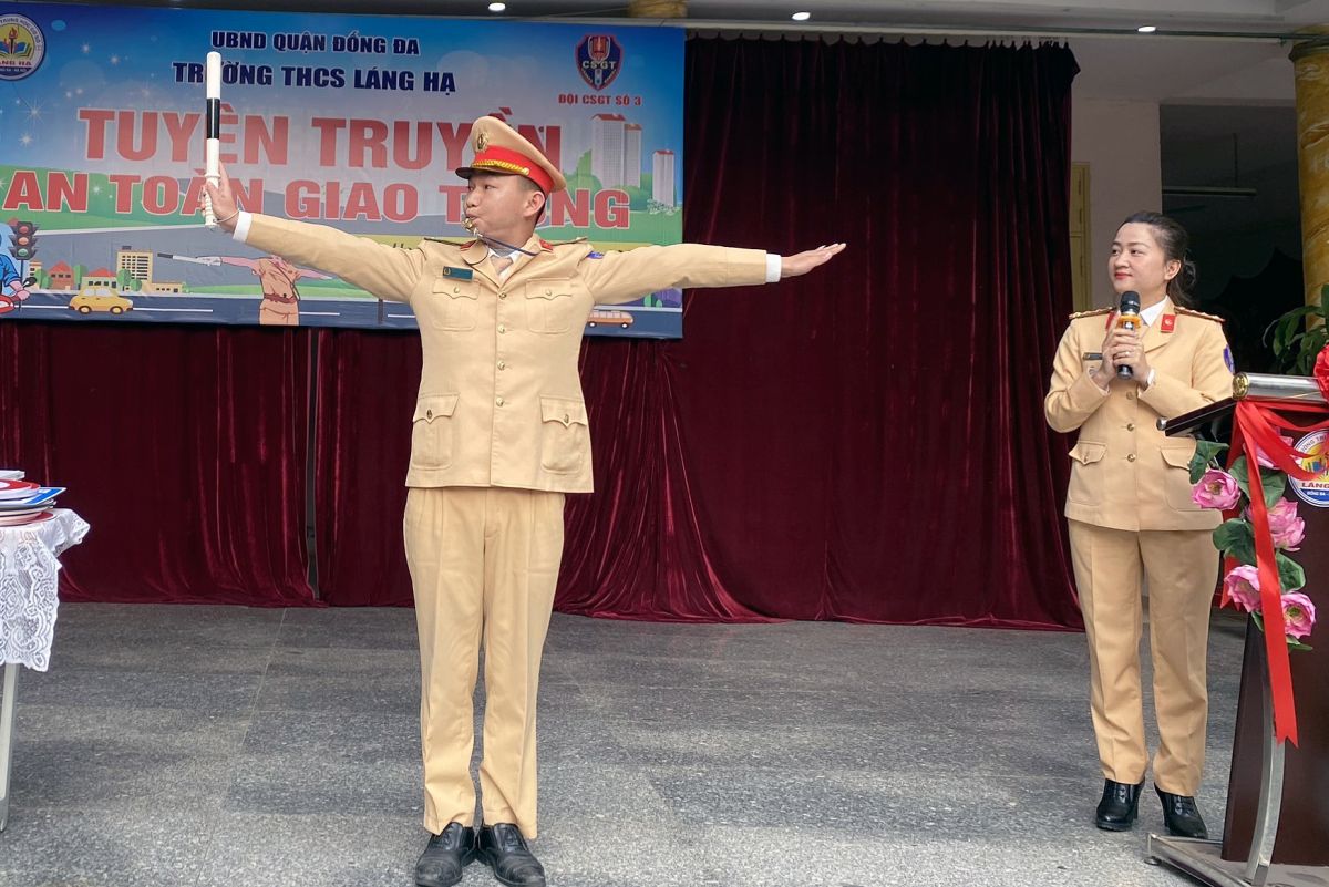 Học sinh Trường THCS Láng Hạ (quận Đống Đa, Hà Nội) được trải nghiệm các động tác chỉ huy, hướng dẫn điều khiển giao thông ngoài thực tế của các chiến sĩ Cảnh sát giao thông.