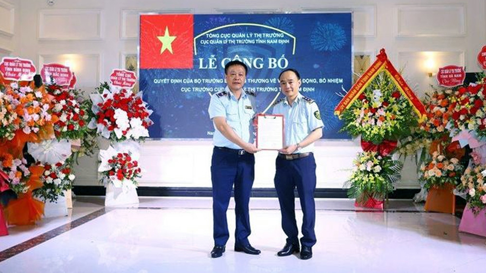 Phó Tổng Cục trưởng Tổng cục Quản lý thị trường Hoàng Ánh Dương trao Quyết định bổ nhiệm cho tân Cục trưởng Cục QLTT tỉnh Nam Định Lê Quang Tú.