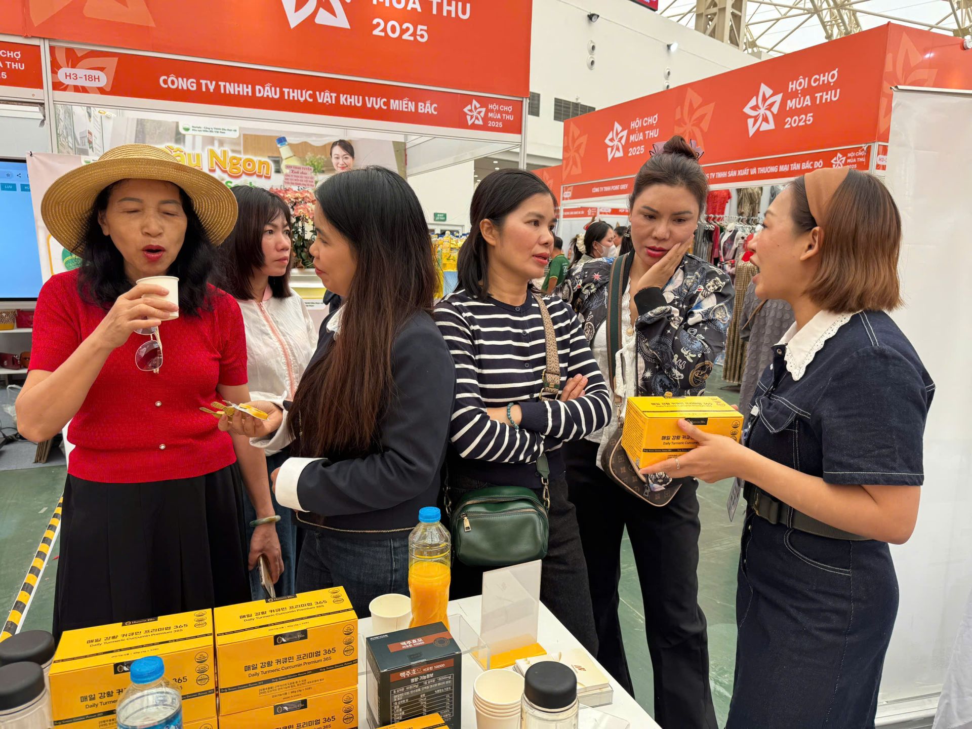 Khách hàng tìm hiểu thông tin sản phẩm tại gian hàng Hân OHUI - nơi trưng bày dòng Nghệ Curcumin Premium 365. Khách hàng tìm hiểu thông tin sản phẩm tại gian hàng Hân OHUI - nơi trưng bày dòng Nghệ Curcumin Premium 365.