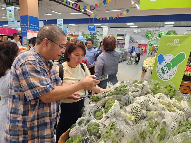 Chủ tịch Hội Công nghệ cao Thành phố Đào Hà Trung hướng dẫn người tiêu dùng truy xuất nguồn gốc sản phẩm. Ảnh: VGP/LA