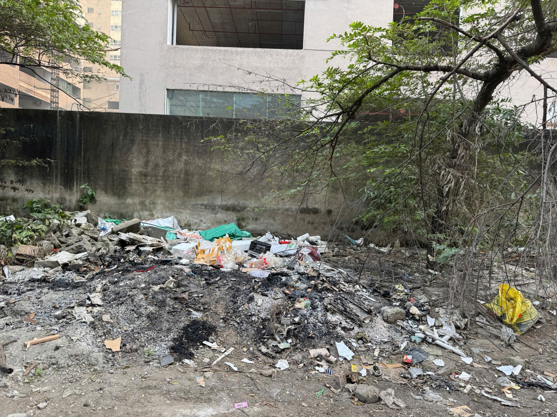 Rác tồn đọng ngay dưới chân chung cư, thường xuyên phải gom đốt gây ô nhiễm mô trường. (Ảnh: Phương Di)