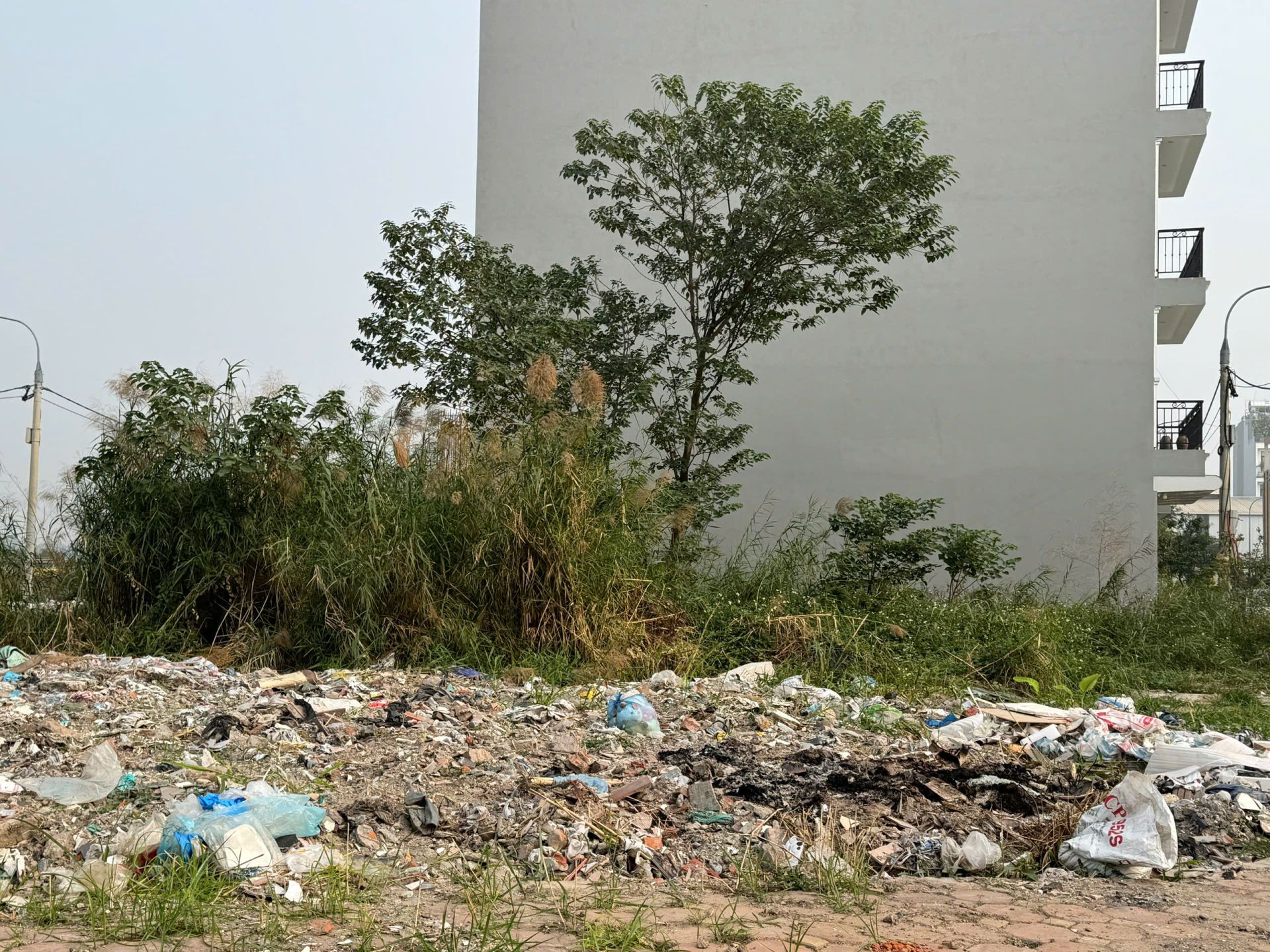 Khu đất trống trong khu dân cư trở thành điểm đổ rác tự phát, người dân sống gần phải lắp camera để giám sát không cho đổ rác bừa. (Ảnh: Phương Di)