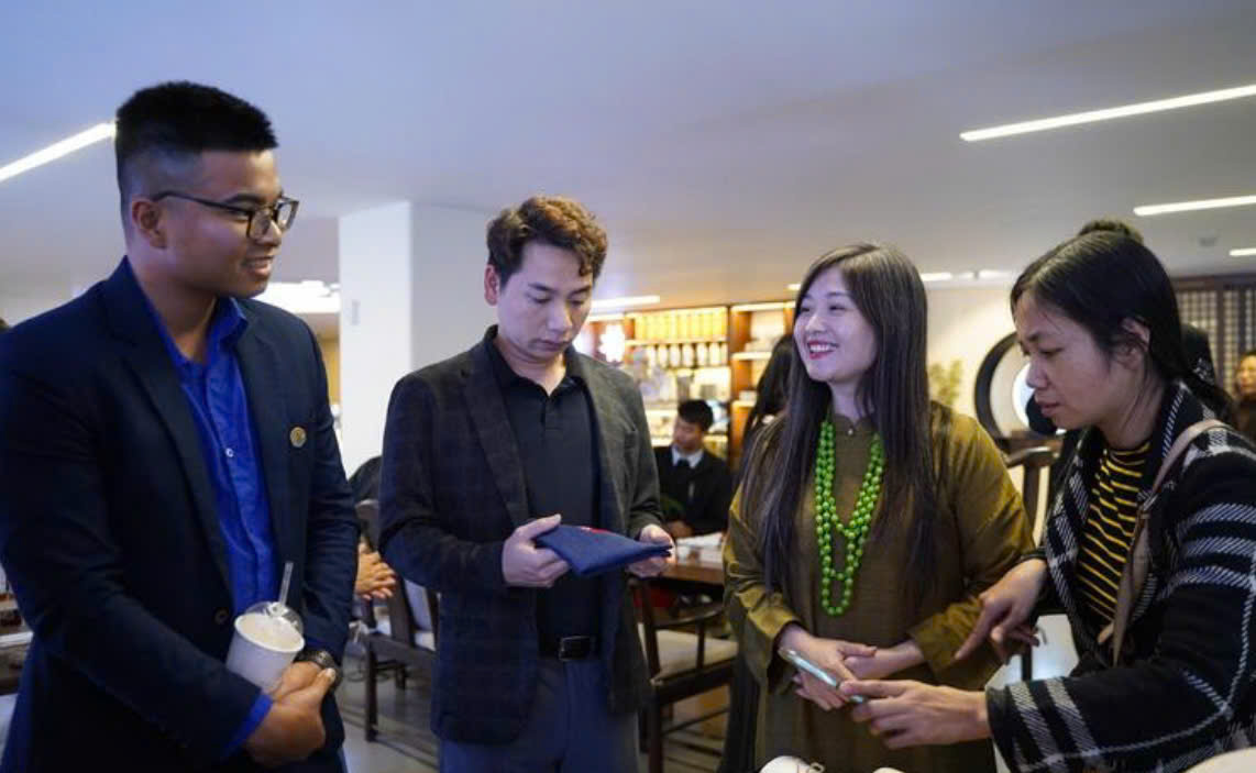 Chị Lương Thanh Hạnh, Gi&aacute;m đốc Hợp t&aacute;c x&atilde; Lụa đũi Nam Cao (tỉnh Hưng Y&ecirc;n) (thứ 2 từ phải sang) đang trao đổi với kh&aacute;ch h&agrave;ng về sản phẩm của HTX. (Ảnh: N.H)