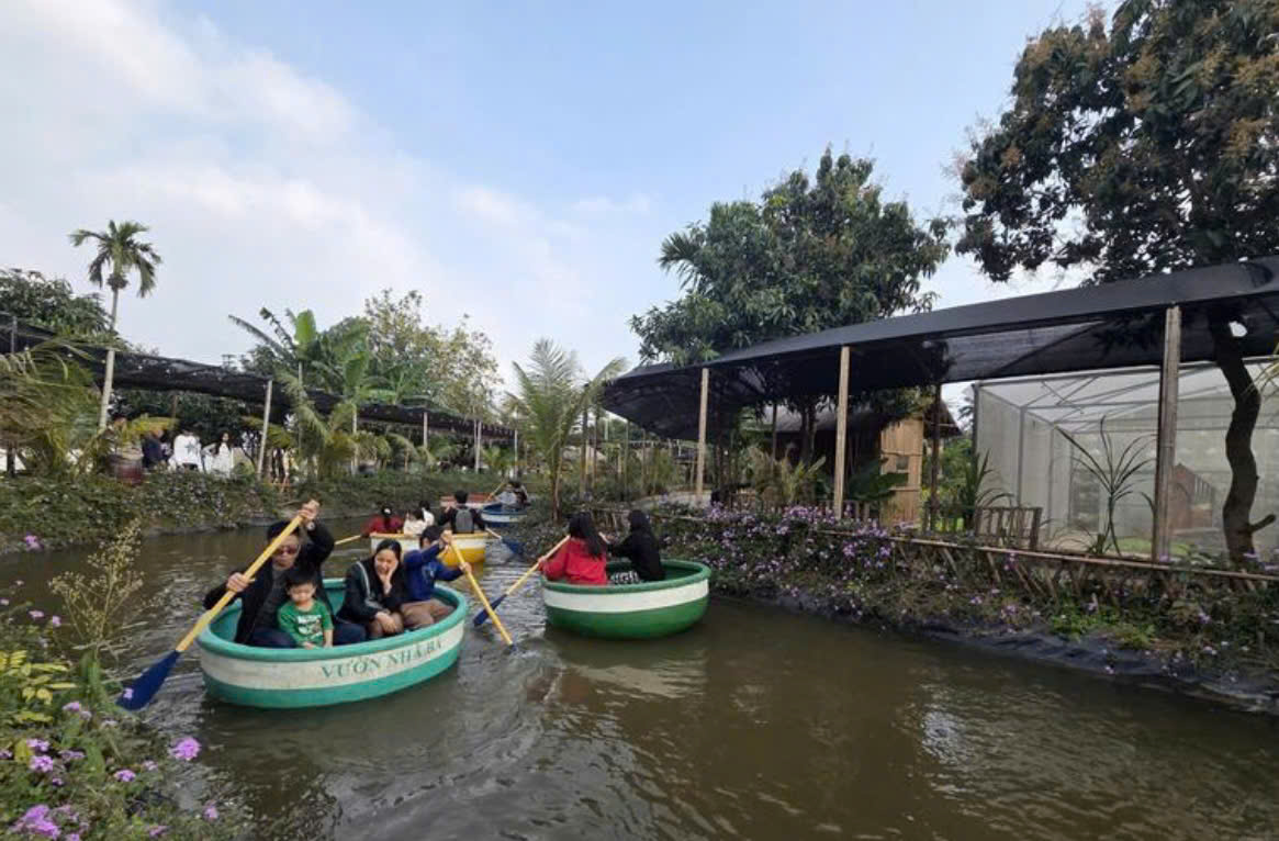 C&aacute;c gia đ&igrave;nh trải nghiệm ch&egrave;o thuyền, tham quan cảnh quan sinh th&aacute;i tại khu vui chơi Vườn của b&agrave; ven s&ocirc;ng Hồng.