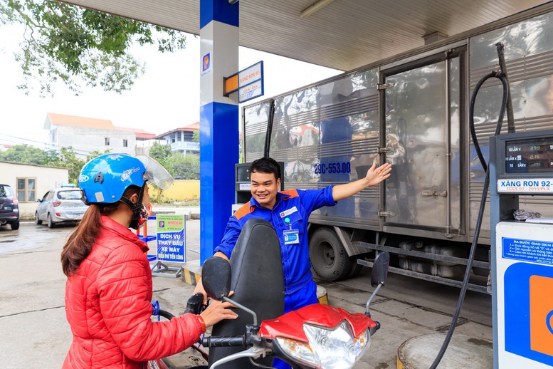 Nh&acirc;n vi&ecirc;n Petrolimex phục vụ kh&aacute;ch h&agrave;ng mua xăng dầu