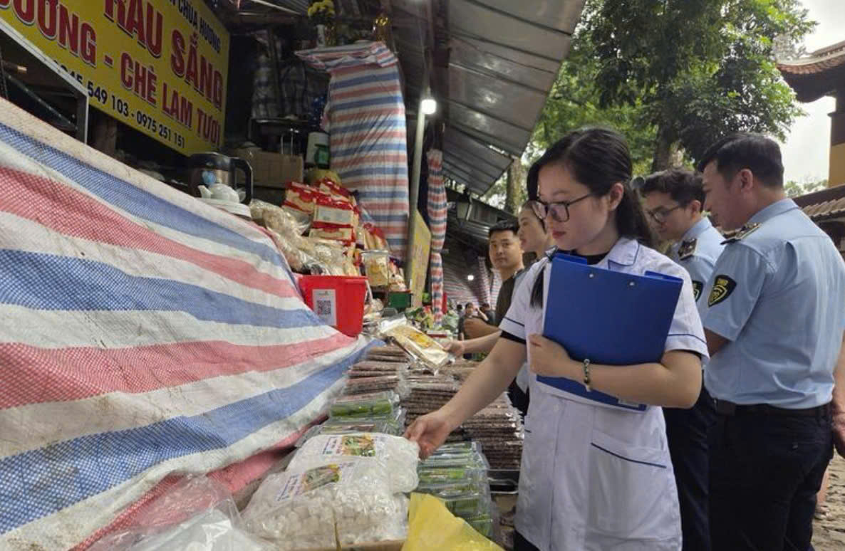 Lực lượng quản l&yacute; thị trường phối hợp với lực lượng y tế kiểm tra điều kiện bảo đảm an to&agrave;n thực phẩm tại c&aacute;c quầy h&agrave;ng phục vụ du kh&aacute;ch trong khu vực lễ hội.