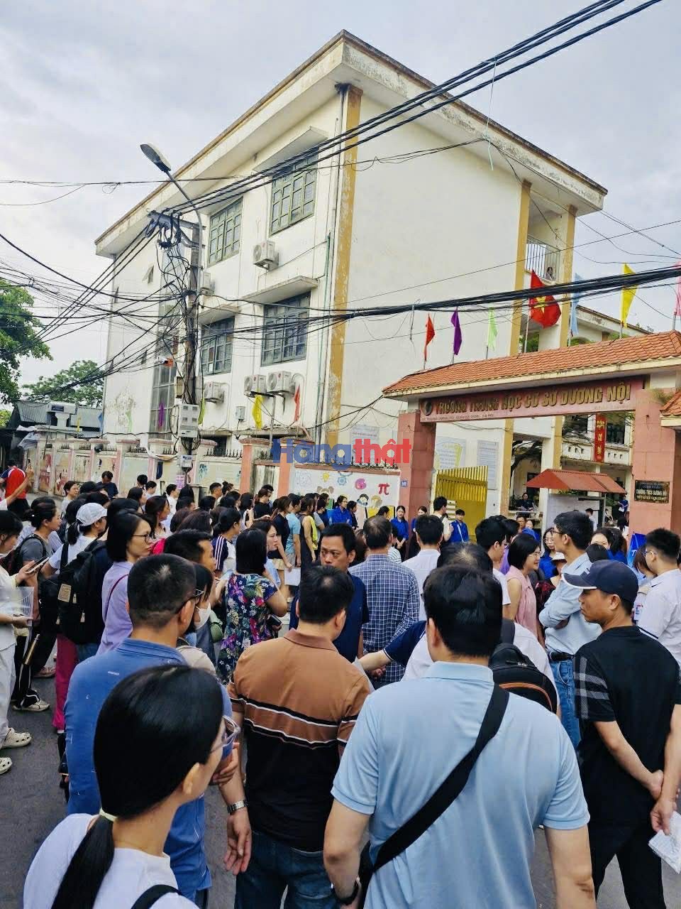 Kh&ocirc;ng kh&iacute; b&ecirc;n ngo&agrave;i điểm thi Trường THCS Dương Nội - nơi đặt điểm thi của Trường THPT L&ecirc; Qu&yacute; Đ&ocirc;n - trở n&ecirc;n căng thẳng khi h&agrave;ng trăm phụ huynh n&aacute;n lại chờ con ho&agrave;n th&agrave;nh b&agrave;i thi thay v&igrave; trở về nh&agrave;.