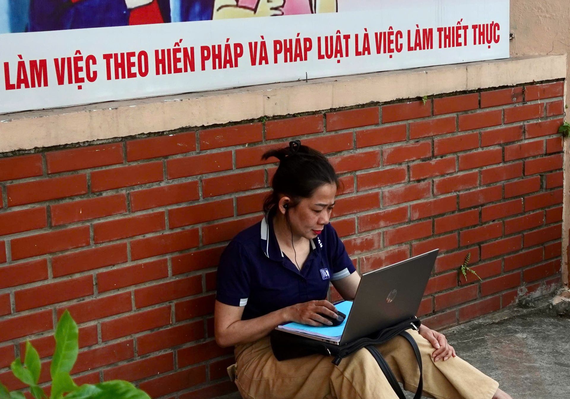 Phụ huynh mang theo m&aacute;y t&iacute;nh để l&agrave;m việc từ xa trong l&uacute;c chờ th&iacute; sinh ho&agrave;n th&agrave;nh m&ocirc;n thi