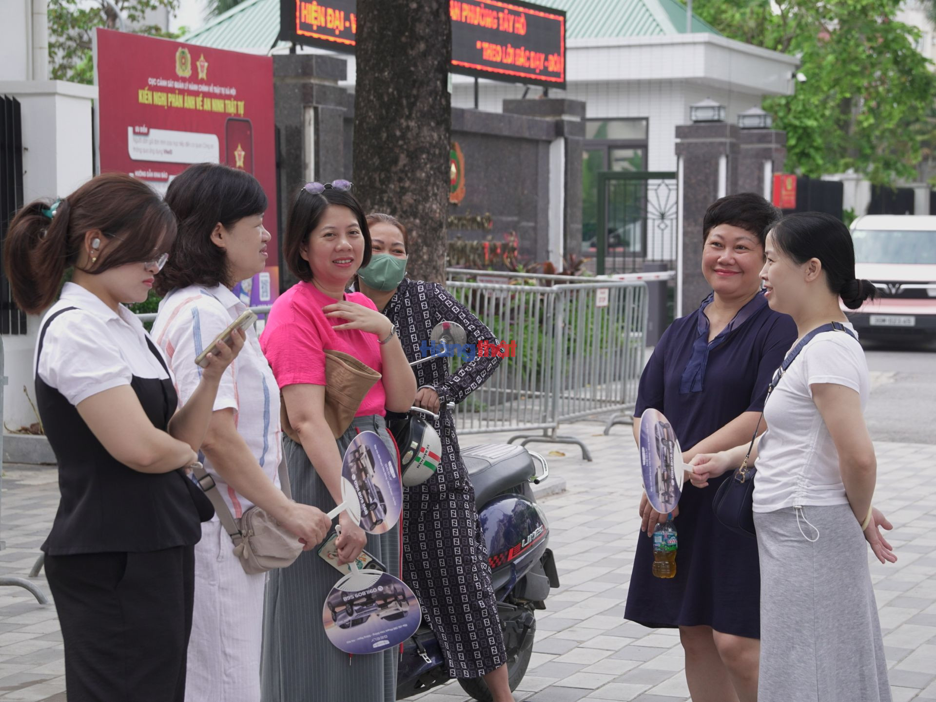 Một số phụ huynh lựa chọn ngồi dưới b&oacute;ng c&acirc;y hoặc khu vực l&acirc;n cận điểm thi để đợi con ho&agrave;n th&agrave;nh b&agrave;i l&agrave;m.