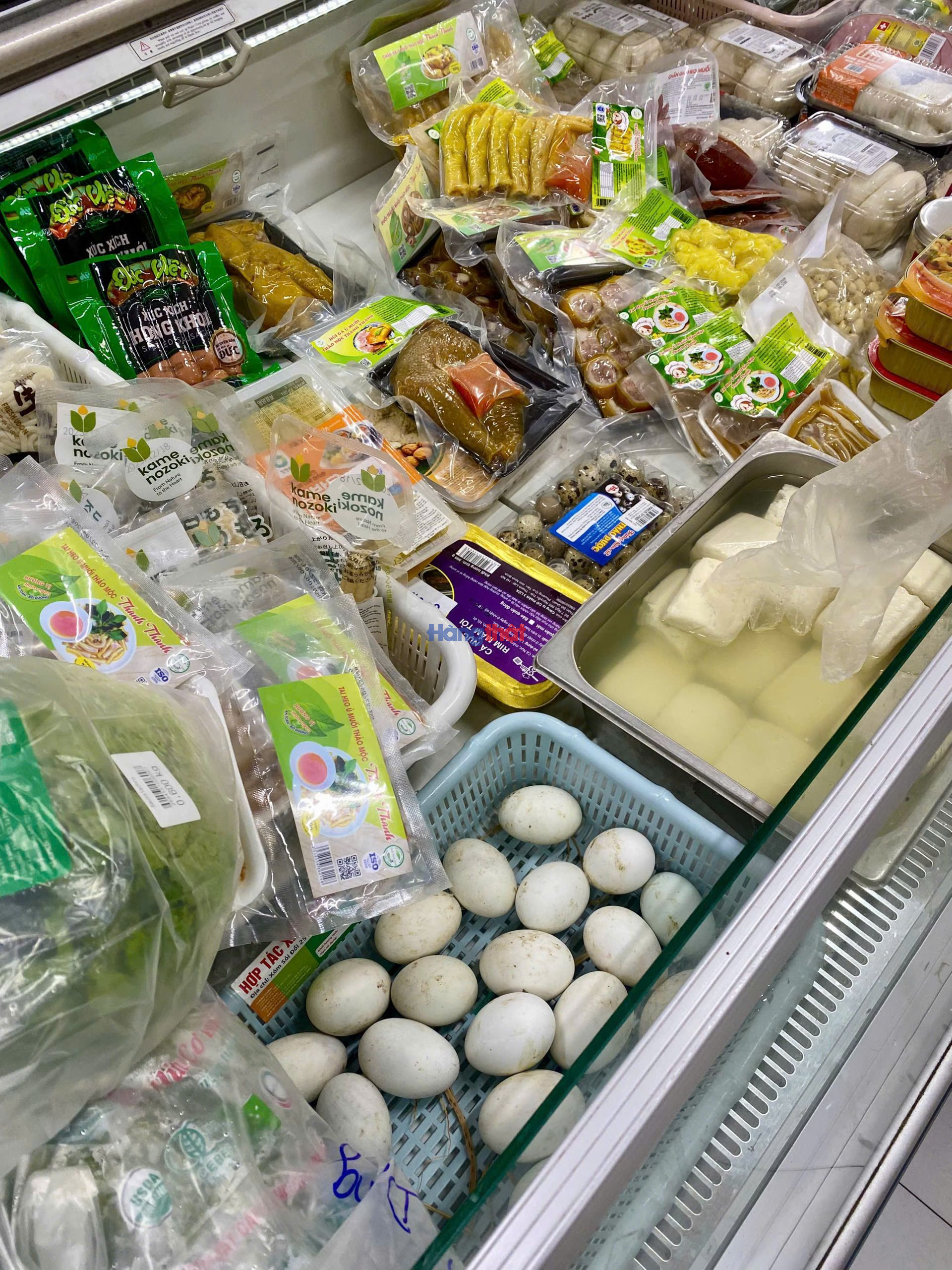 Tại cơ sở Tomita Mart Kh&uacute;c Thừa Dụ, ph&oacute;ng vi&ecirc;n ghi nhận trứng sống c&oacute; vỏ c&ograve;n b&aacute;m bẩn v&agrave; đậu phụ được b&agrave;y để lẫn trong c&ugrave;ng quầy m&aacute;t, cho thấy dấu hiệu bảo quản chưa bảo đảm tại thời điểm khảo s&aacute;t
