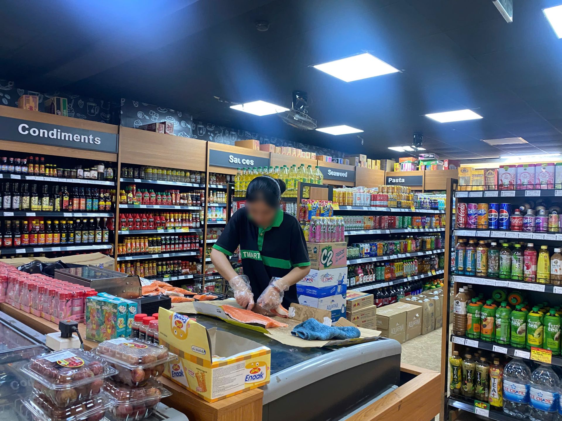 Theo ghi nhận của ph&oacute;ng vi&ecirc;n, nh&acirc;n vi&ecirc;n tại cơ sở T-Mart Ecohome 1 trực tiếp sơ chế v&agrave; chia phần c&aacute; hồi sống để đ&oacute;ng khay b&aacute;n lẻ; thời điểm ghi nhận, nh&acirc;n vi&ecirc;n chỉ sử dụng găng tay, kh&ocirc;ng đội mũ v&agrave; kh&ocirc;ng đeo khẩu trang